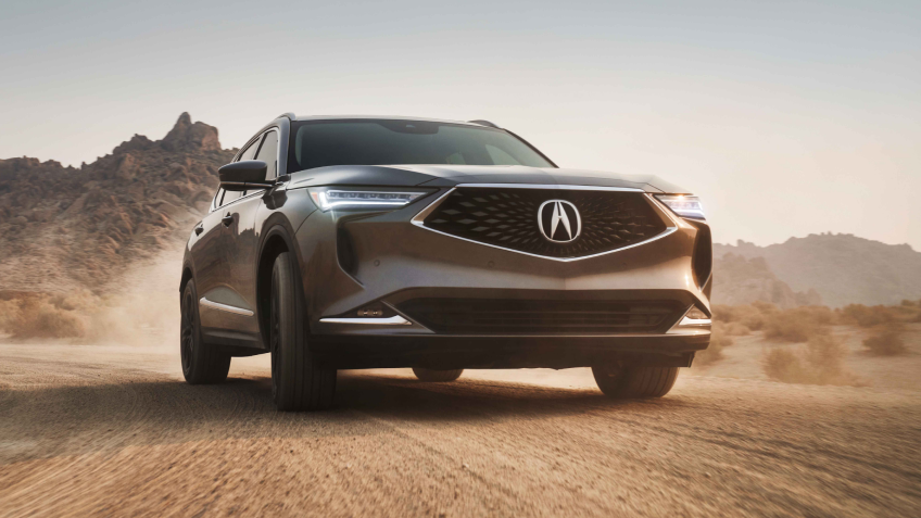 Vue 3/4 du MDX couleur champagne sur une route désertique.