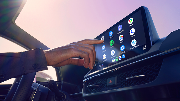 Cllose-up of driver using Google-built in on the dashboard display. 