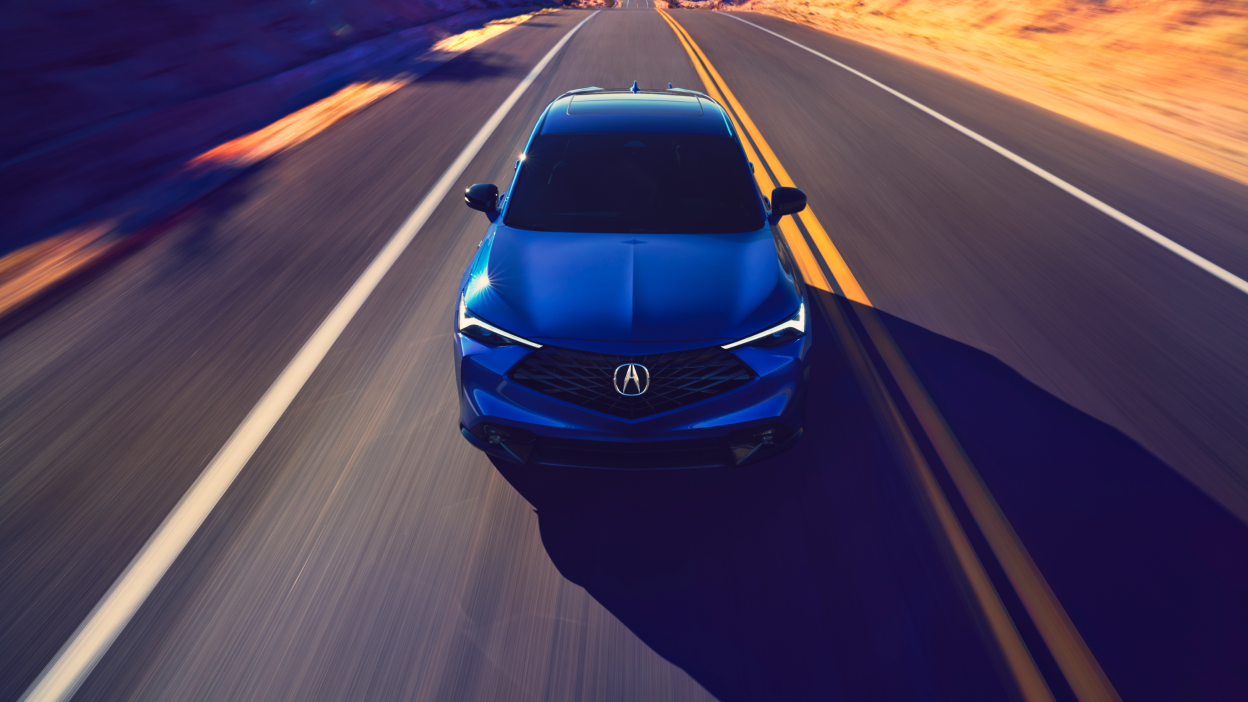 Acura ADX vu de l’avant sur une autoroute avec des lignes bleues sortant de la calandre.