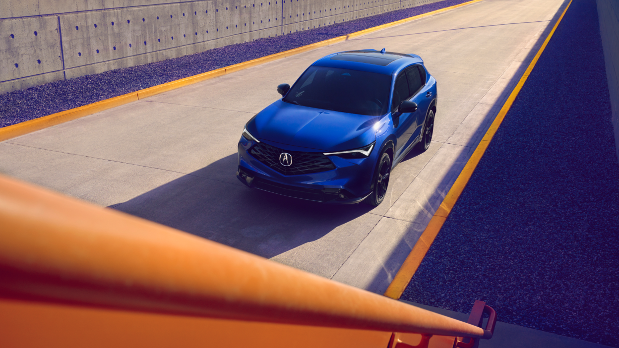 Overhead wide-shot of a blue Acura ADX on a road. 