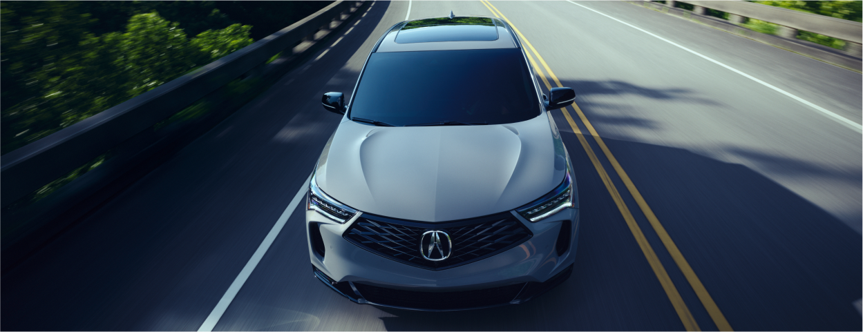 Plan de trois quarts en plongée d’un RDX gris circulant sur l’autoroute par une journée ensoleillée.