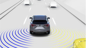 Représentation numérique où tout est blanc sauf le RDX. Plan arrière élargi d’un RDX gris roulant sur une route. Des ondes bleues et jaunes détectent les véhicules en périphérie.