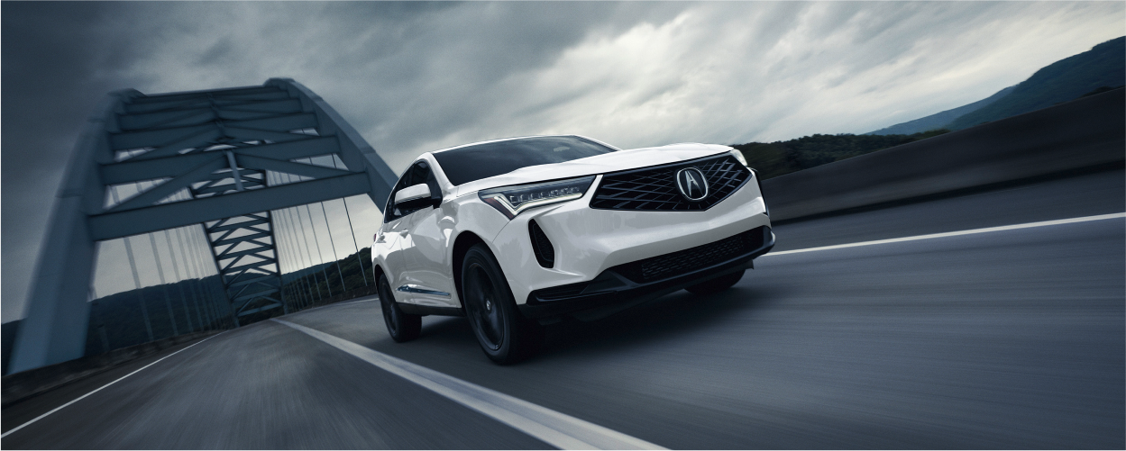 Vue complète de profil d’un RDX gris dans un entrepôt avec éclairage rouge en arrière-plan. 