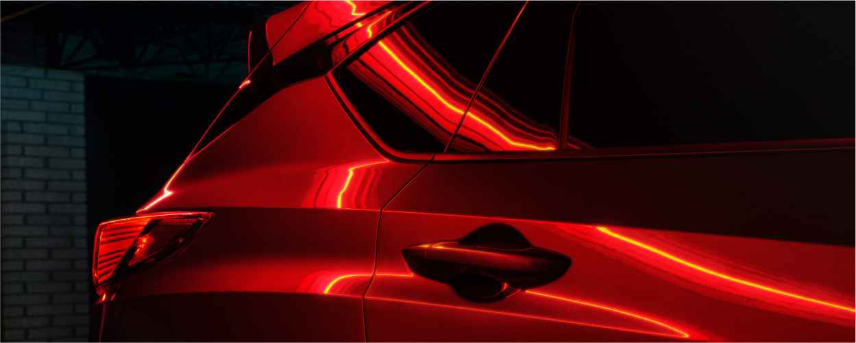 Vue 3/4 avant d’un RDX bleu dans un entrepôt, des rayons de soleil passant par les fenêtres.