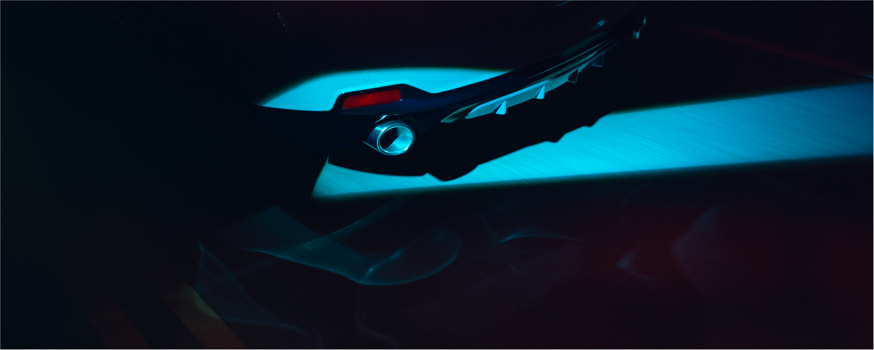 Vue 3/4 arrière du RDX en conduite de nuit. L'embout du tuyau d'échappement est mis en valeur par un projecteur.