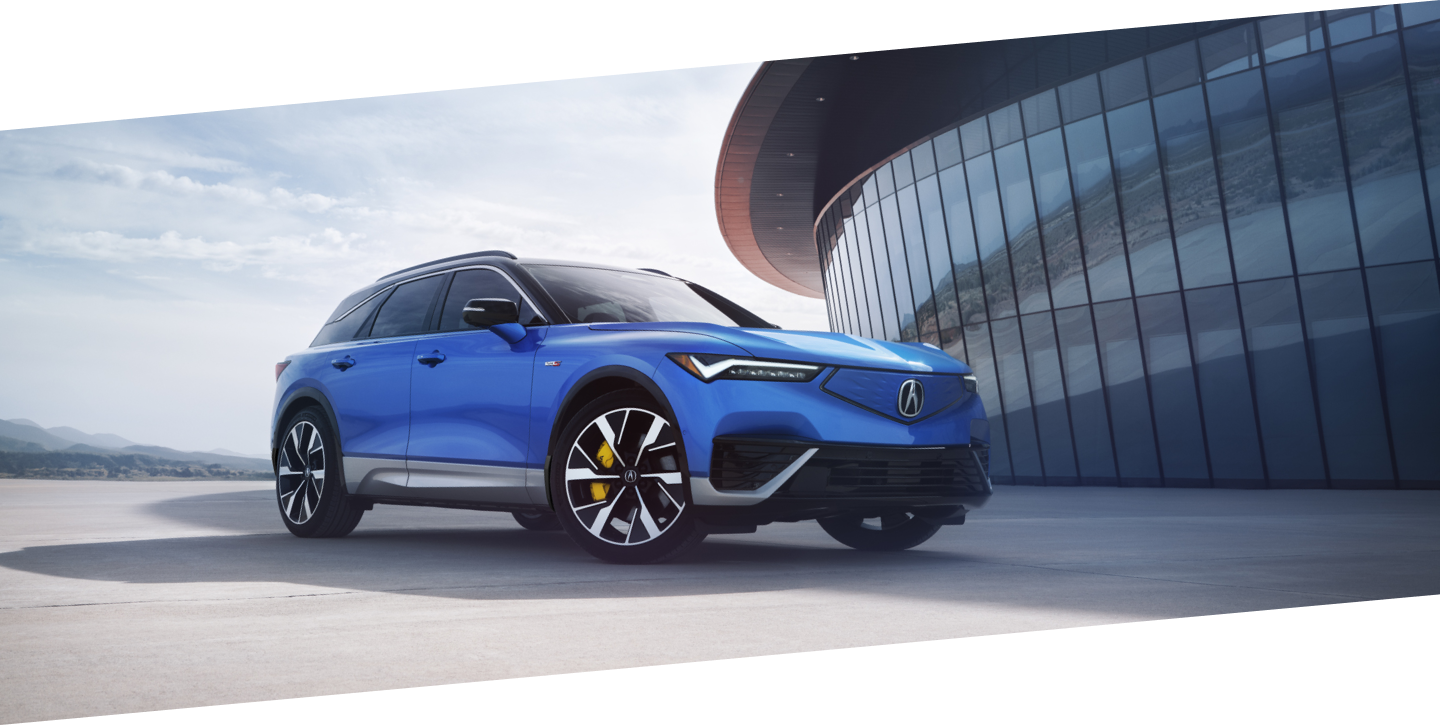 Vue 3/4 avant du ZDX bleu stationné à l'extérieur d'un bâtiment moderne en verre au coucher du soleil.