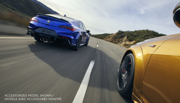 Plan de trois quarts arrière d’une Integra Type S bleue roulant sur une autoroute aux côtés d’une Integra Type S de couleur or.