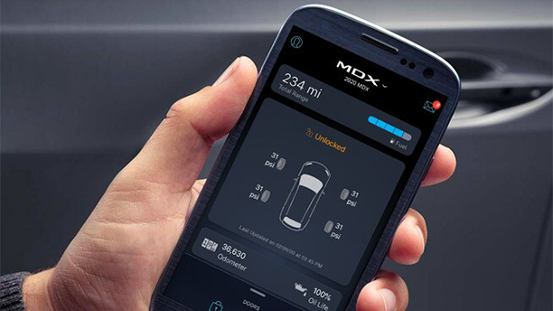 A hand holds a smartphone open to the Acura Link app. Une main tient un téléphone intelligent ouvert sur le lien de l’application Acura.